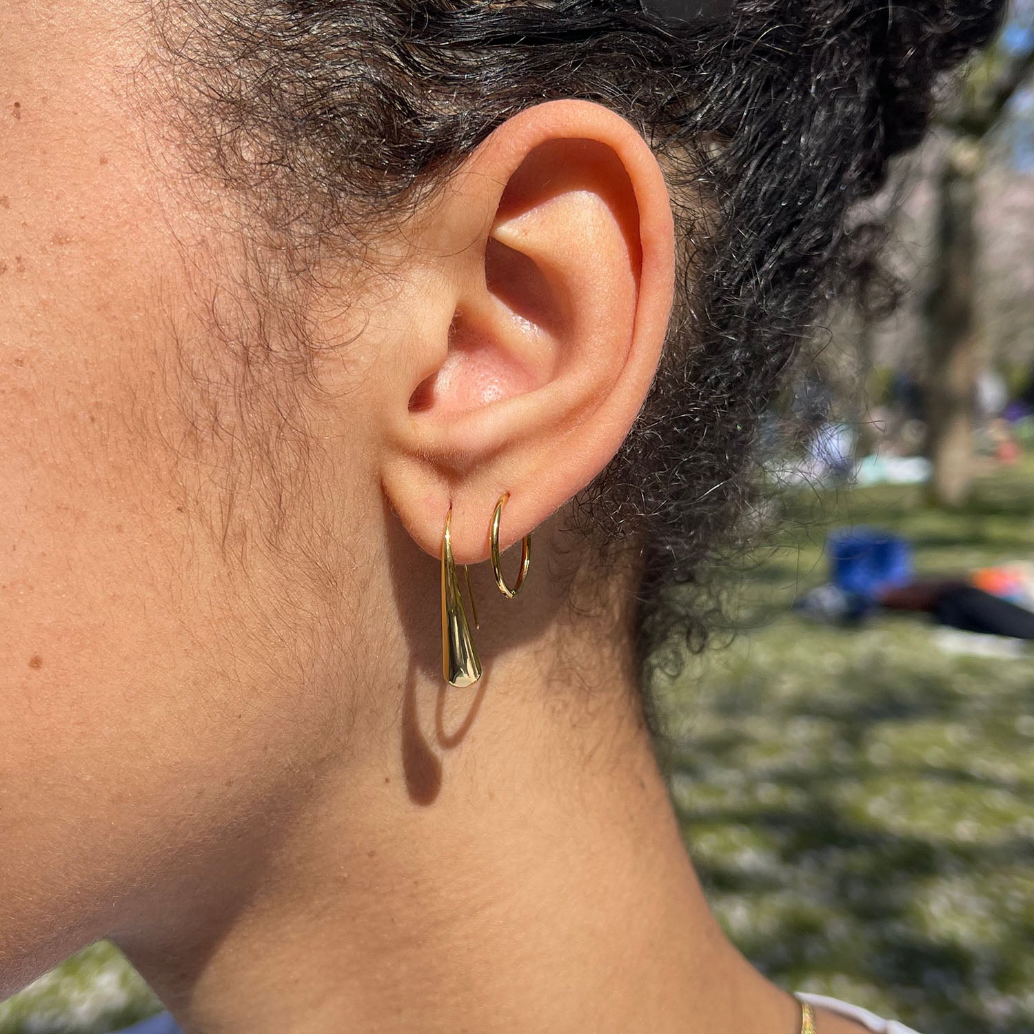 girl wearing stainless steel earring tear shape gold