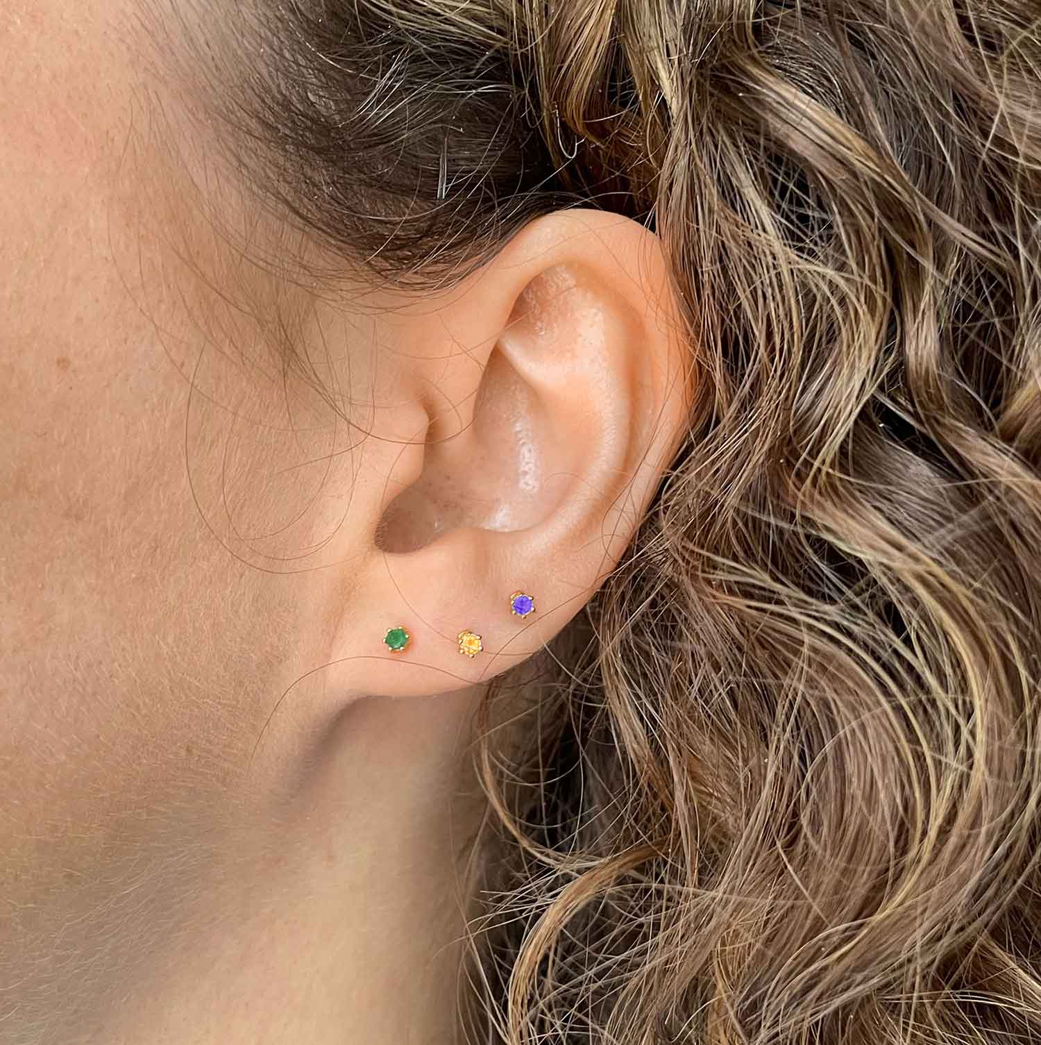 model with gold plated peridot ear stud