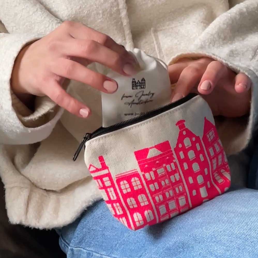 girl taking out jewelry from mini pouch pink