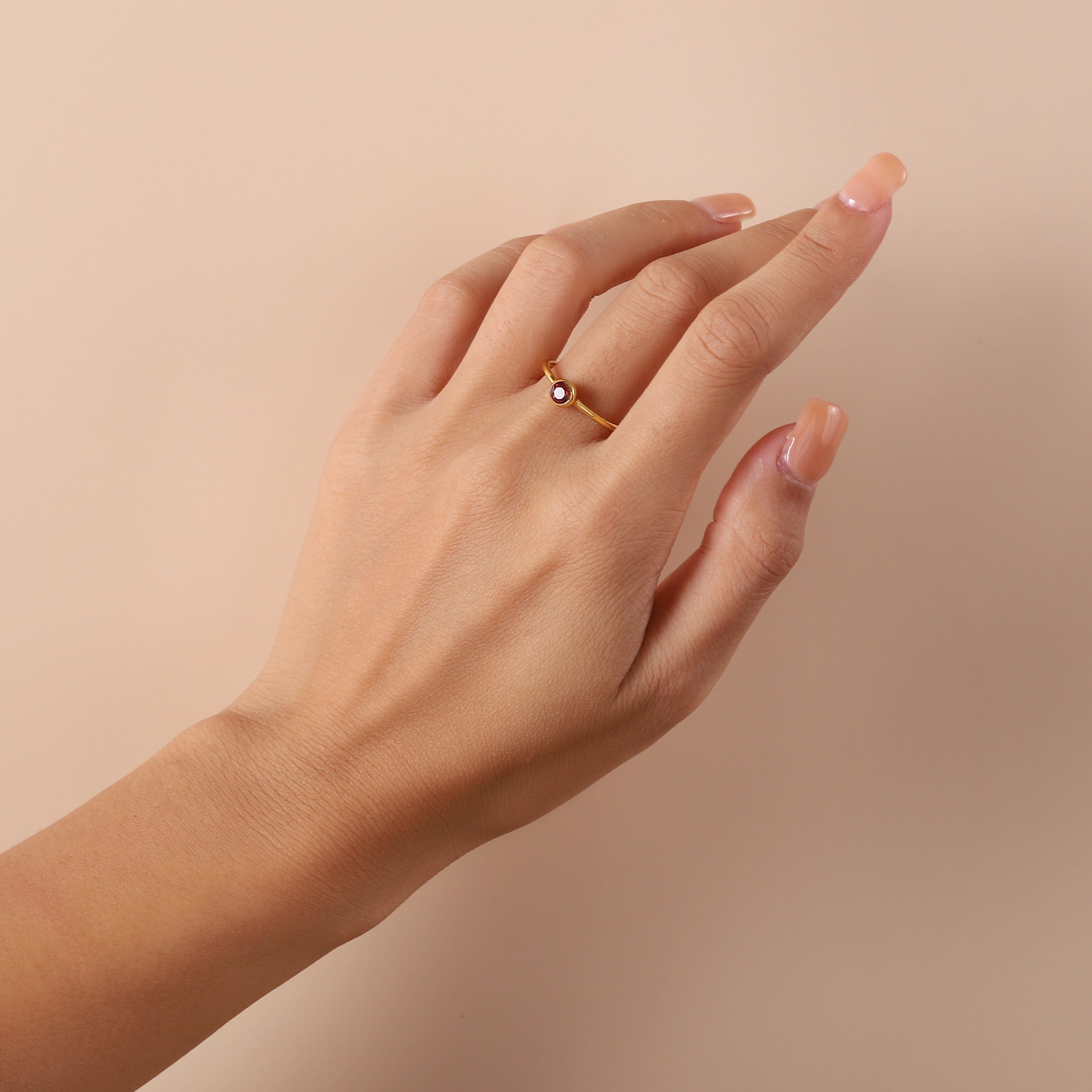 gold palted ring with red garnet on model