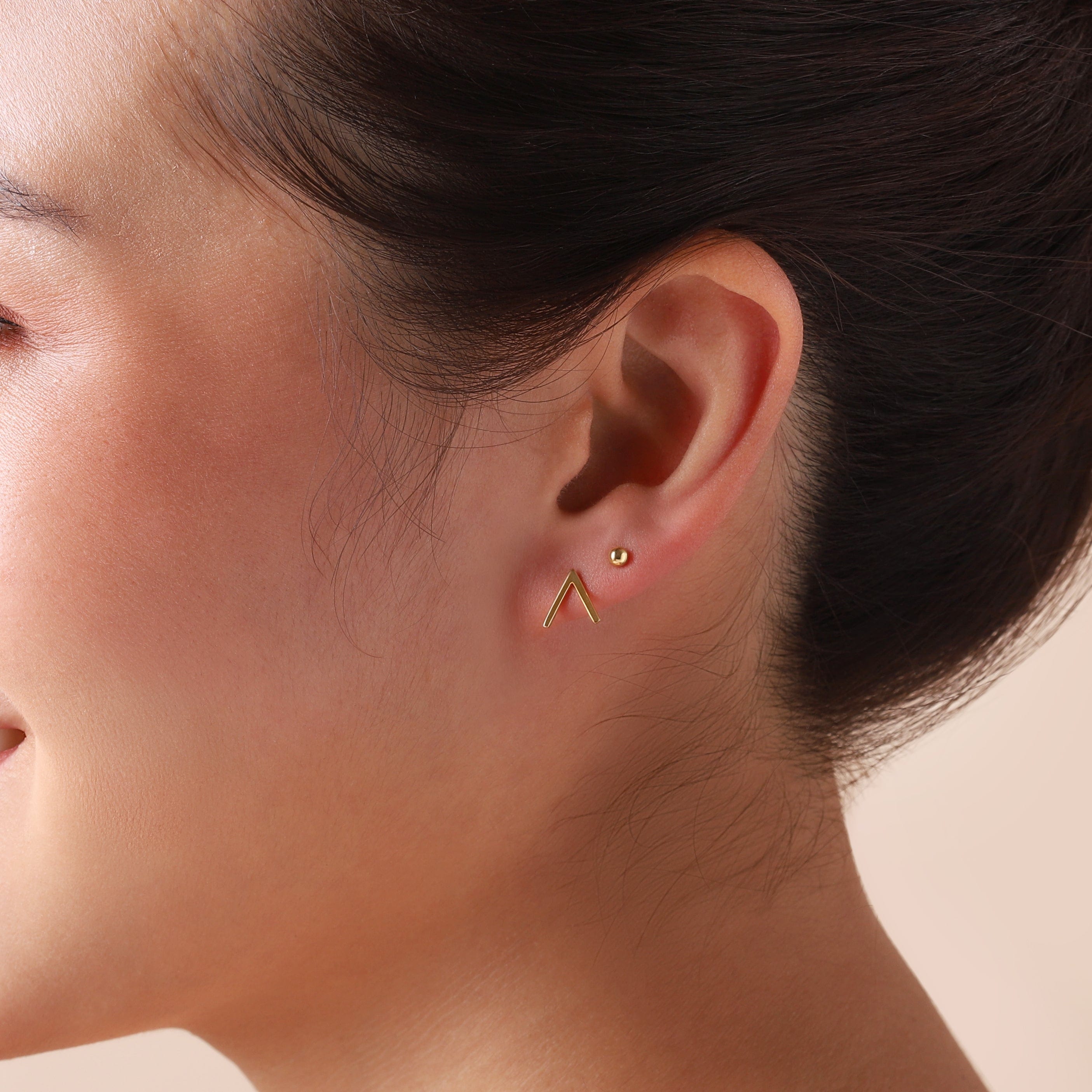 gold plated v-sign stud earrings on model