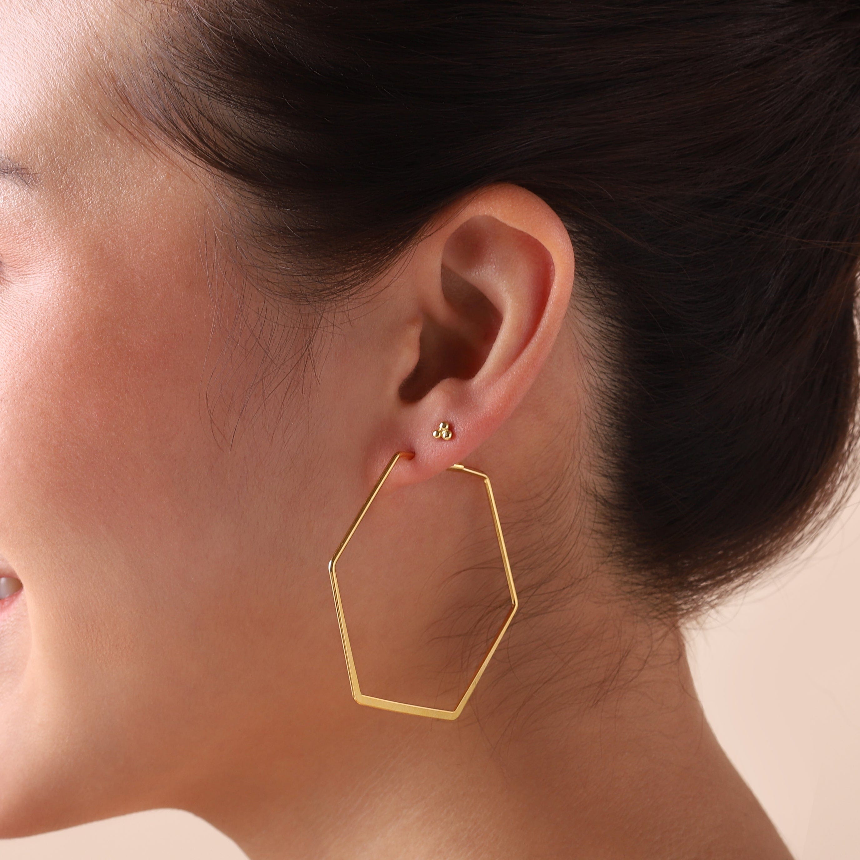 gold plated triple stud earrings on model