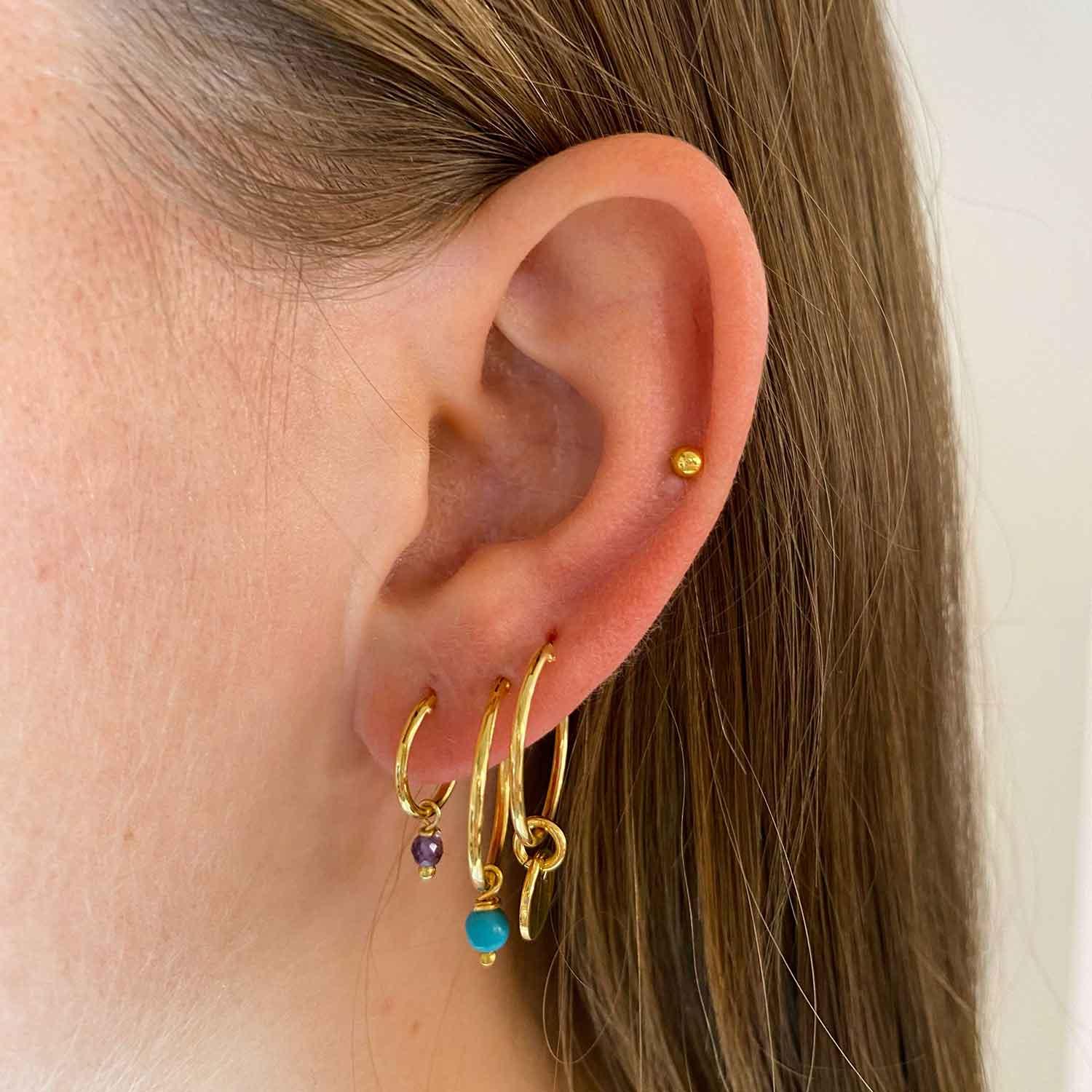 model with 18 mm gold plated hoop earrings with round pendant
