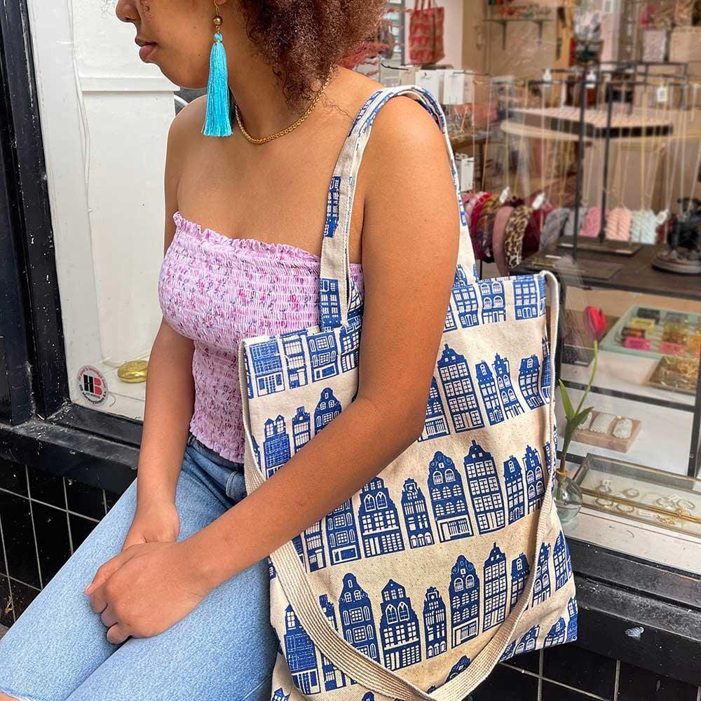 girl with shoulder bag with canal houses in blue