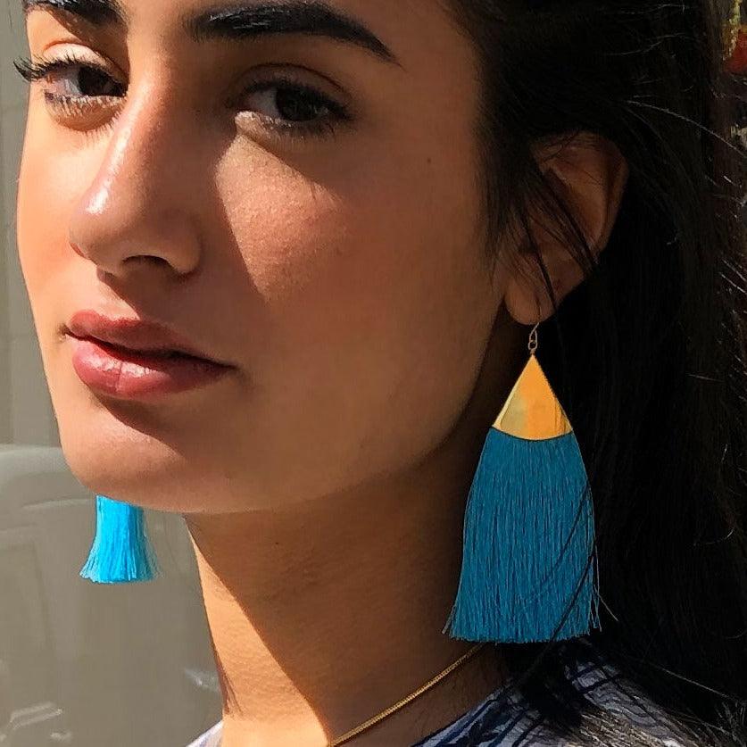 model with blue tassel brush earring