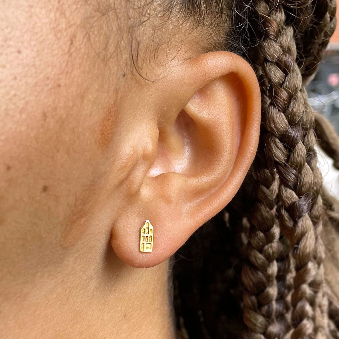 ear model with an Amsterdam Canal house ear stud gold plated