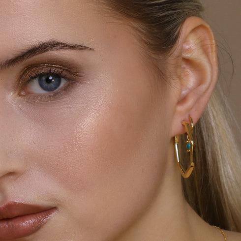model with gold plated hexagon earrings