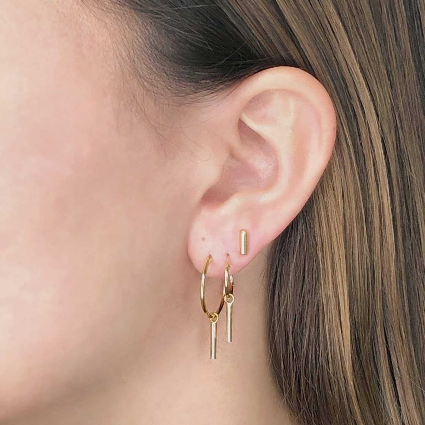 model with 22mm gold plated hoop earrings with long rod