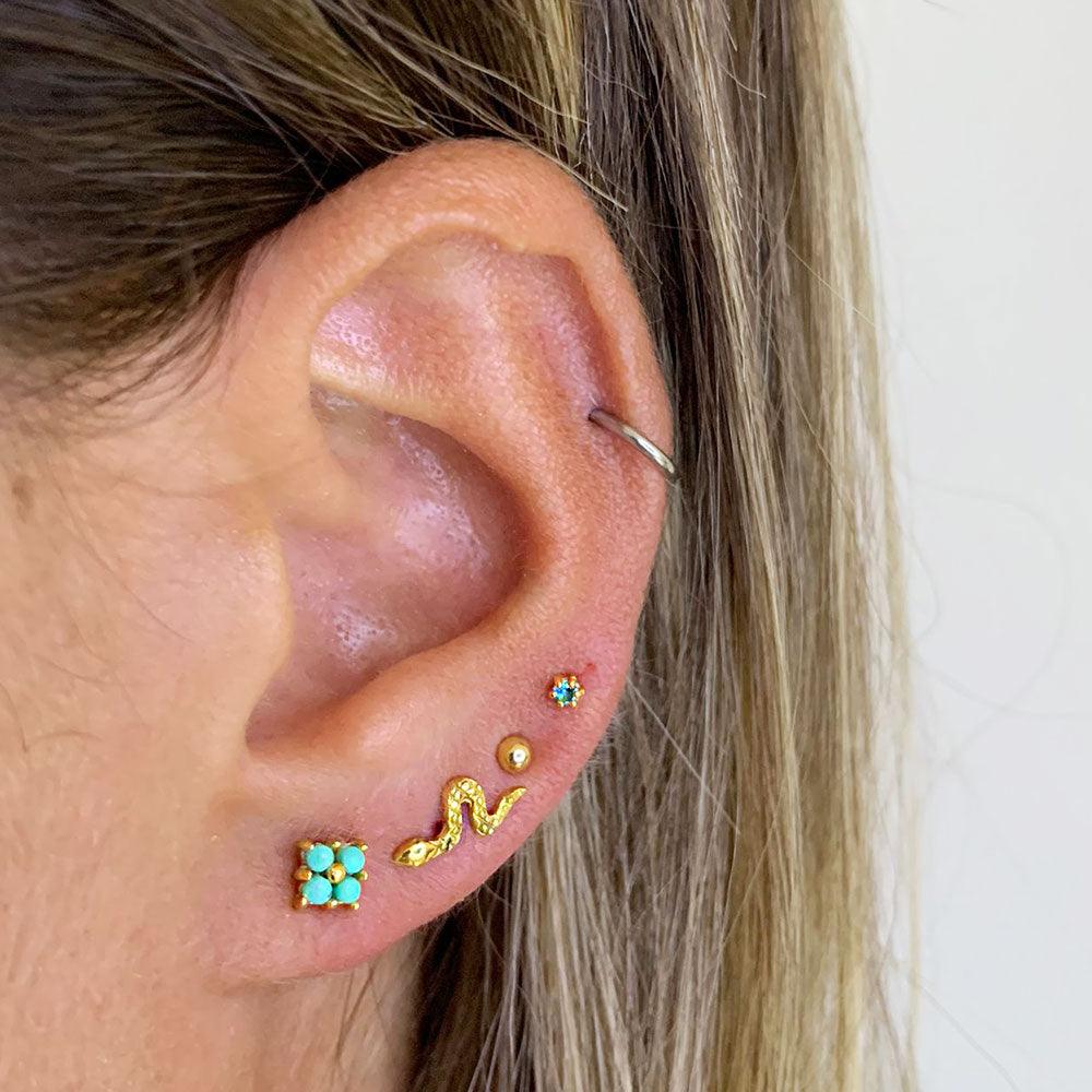 Model with square turquoise ear stud gold plated. Also snake and classic studs.
