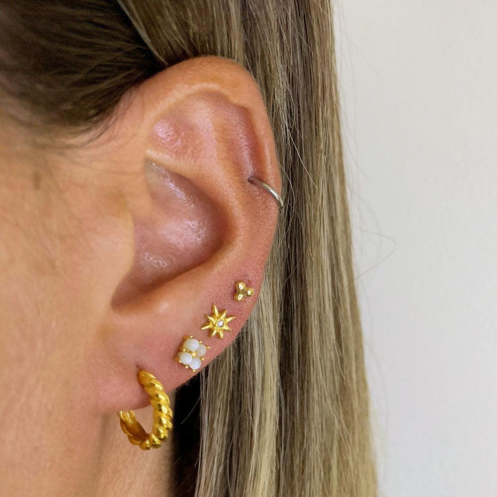 model with gold plated square earring with pearls. And three more earrings.